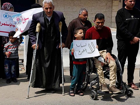 Palestinians attend a gathering outside UN offices to protest a decision by World Food Program to suspend aid of around 200,000 people in the Gaza Strip and the West Bank, in Gaza City, May 7, 2023.