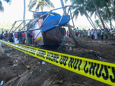 People look at a tourist boat that capsized Sunday night in Malappuram, Kerala, on May 8, 2023.