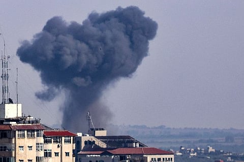A plume of smoke rises above buildings during an Israeli strike on Gaza City, on May 10, 2023.