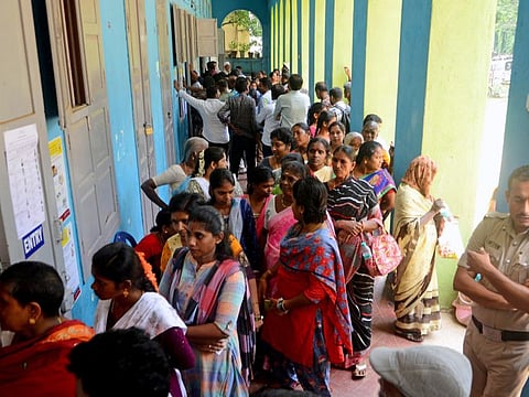 Voters wait to cast their votes for the Karnataka assembly elections, at a polling station in Bengaluru on Wednesday.