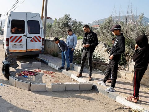 People stand near the site where two Palestinians were killed in an Israeli raid in Qabatiya, near Jenin.