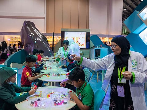 Young students building their own battery-operated cars at the 'Tesla Electric Car' workshop at SCRF in Sharjah.