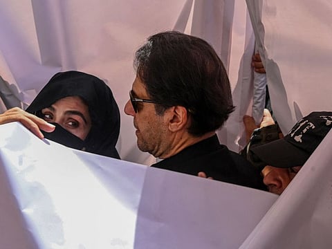 Former Pakistan prime minister Imran Khan with his wife Bushra Bibi arrive to appear at a high court in Lahore on May 15, 2023.