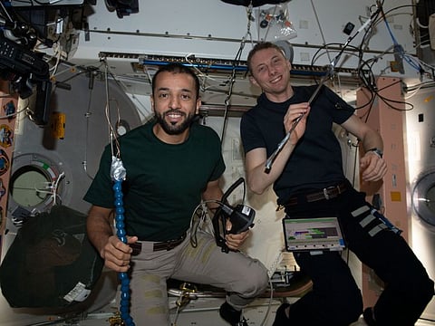 UAE astronaut Sultan Al Neyadi and his colleague Warren Hoburg holding the tools used to open the "Unity" module space-facing side aboard the International Space Station.