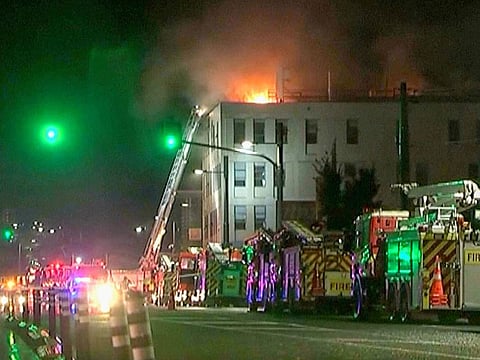 In this image made from video, firetrucks stage outside a hostel in central Wellington, New Zealand, early Tuesday, May 16, 2023. Several people were killed after a fire broke out overnight at the four-story building.