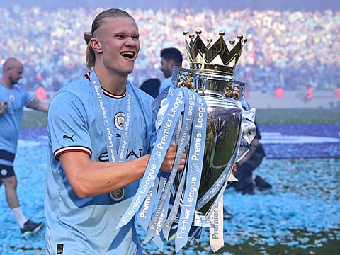 Manchester City's Norwegian striker Erling Haaland poses with the Premier League trophy on the pitch after the presentation following the match against Chelsea at the Etihad Stadium in Manchester, north west England. City won the Premier League for the fifth time in six seasons.