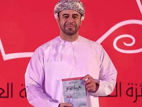 Omani author Zahran Al Qasimi with his award-winning book.