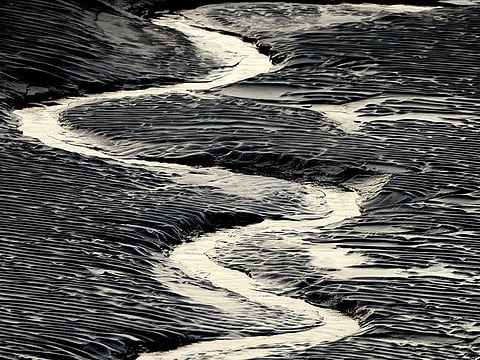 A channel flows through the mud flats along the Seward Highway and Turnagain Arm in Alaska on Oct. 25, 2014