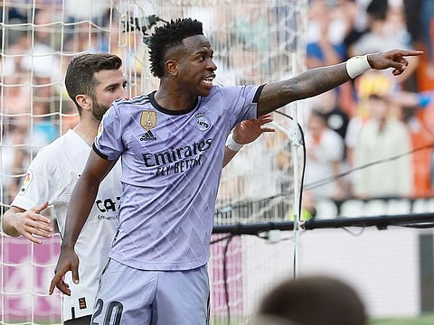 Real Madrid's Brazilian forward Vinicius Junior reacts to being insulted pointing at the stands during the Spanish league football match against Valencia CF at the Mestalla stadium in Valencia on May 21, 2023.