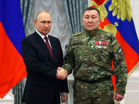 Russian President Vladimir Putin awards deputy commander of the BARS-2 volunteer unit Alexander Kolesov with the Hero of Russia order during a state awards ceremony at the Kremlin in Moscow on May 23, 2023.