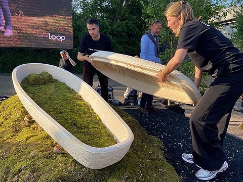 Director Lonneke Westhoff, right, and founder Bob Hendrikx, left, of Dutch startup Loop Biotech display one of the cocoon-like coffins.