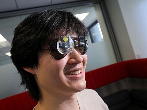 Bryan Chiang, a 22-year-old computer science major and aspiring start-up creator, wears an augmented reality eyepiece equipped with RizzGPT in San Francisco, California.