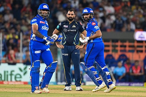 Gujarat Titans' Mohammed Shami (centre) watches as Mumbai Indians' Rohit Sharma (right) with teammate Suryakumar Yadav takes a run during the Indian Premier League (IPL) Twenty20 second qualifier at the Narendra Modi Stadium in Ahmedabad.