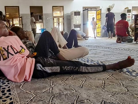 Sudanese people gather in a mosque, where electricity is available via generator, after power cuts in Khartoum on May 26, 2023.