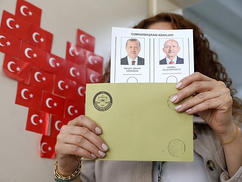 An election representative holds a ballot with presidential candidates at a polling station in Ankara, Turkey, Sunday, May 28, 2023.