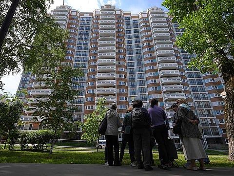 People look at a the apartment building in Moscow, Russia, damaged by a drone in an attack that authorities blamed on Ukraine, Tuesday, May 30, 2023.