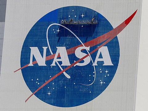 FILE PHOTO: Workers pressure wash the logo of NASA on the Vehicle Assembly Building before SpaceX will send two NASA astronauts to the International Space Station aboard its Falcon 9 rocket, at the Kennedy Space Center in Cape Canaveral, Florida, U.S., May 19, 2020.