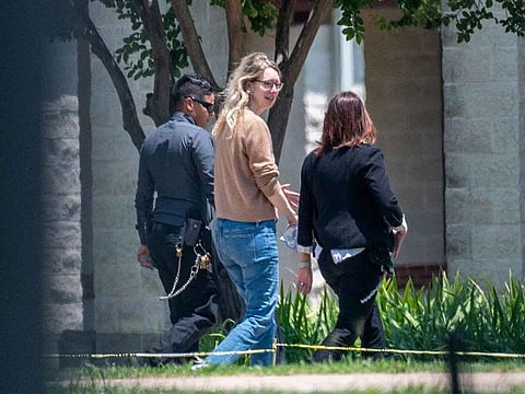 Elizabeth Holmes, founder of Theranos Inc., center, arrives at Federal Prison Camp Bryan in Bryan, Texas, US, on Tuesday, May 30, 2023. Holmes surrendered to authorities on Tuesday to begin her 11 1/4-year sentence after she was convicted by a jury last year of defrauding investors in the blood-testing startup.