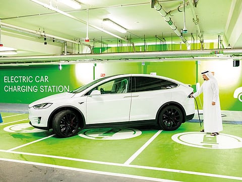 An electric vehicle being charged at a charging station in Dubai