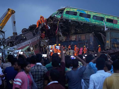 Rescuers work to take out the body of a victim of passenger trains that derailed in Balasore district.