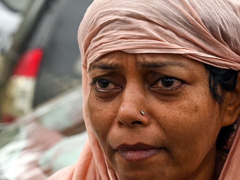 A woman weeps as she searches for her son's body at a high school used as temporary mortuary to identify the dead recovered from the carriage wreckage of a three-train collision near Balasore, in India's eastern state of Odisha, on June 4, 2023.