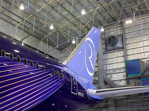 A Boeing 787 in the newly unveiled Riyadh Air livery waits at a hangar.