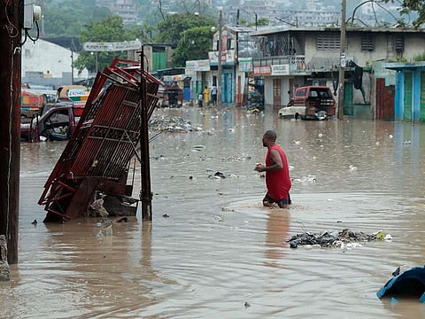 A man wades through a street flooded after a heavy rain in Port-au-Prince, Haiti.