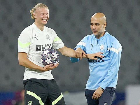 Manchester City manager Pep Guardiola (R) with Manchester triker Erling Haaland during a training session at the Ataturk Olympic Stadium in Istanbul on June 9, 2023.