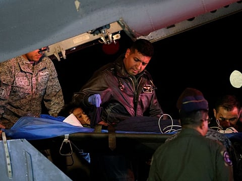 A child survivor from a Cessna 206 plane that crashed in thick jungle is carried on a gurney after arriving from San Jose del Guaviare, at the CATAM military airbase, in Bogota on June 10, 2023.
