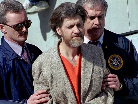 Theodore "Ted" Kaczynski is flanked by federal agents as he is led to a car from the federal courthouse in Helena, Mont., April 4, 1996.