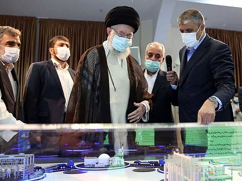 A handout picture made available by the office of Iran's Supreme Leader Ayatollah Ali Khamenei shows him (C) visiting an exhibition of the country's nuclear industry achievements in Tehran, on June 11, 2023, accompanied by the head of the Atomic Energy Organization of Iran Mohammad Eslami (R).