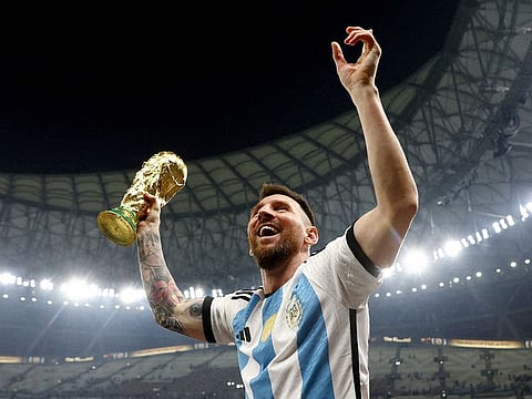 Argentina's Lionel Messi celebrates winning the World Cup with the trophy.