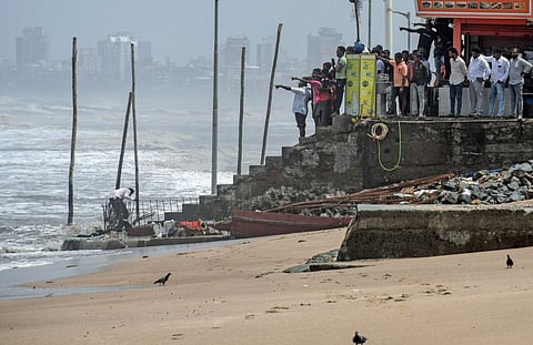People gather at a corner during a search operation at Juhu Beach for four boys who were feared to have drowned during high tide as an impact of Cyclone Biparjoy, in Mumbai on Tuesday.