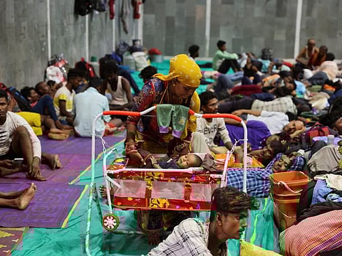 Laxmi Kumar places her son Arvind inside a cradle at a temporary shelter for people evacuated from Kandla port, before the arrival of cyclone Biparjoy, in Gandhidham, in the western state of Gujarat, India, on June 13, 2023.