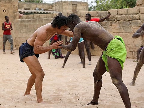 Shogo Uozumi (left) wrestles with Baye Ibra at the Samba Dia stable in the Diakhao neighbourhood, in Thies, Senegal.
