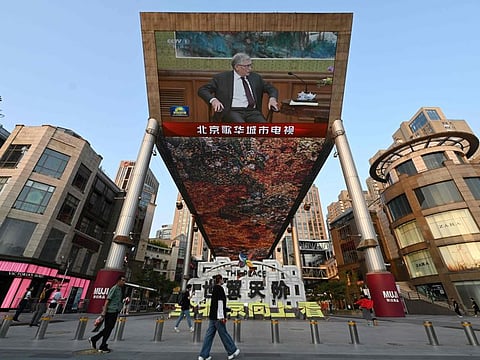 A China Central Television news broadcast shows footage of Microsoft co-founder Bill Gates during his meeting with Chinese President Xi Jinping (not seen), on a giant screen outside a shopping mall in Beijing.