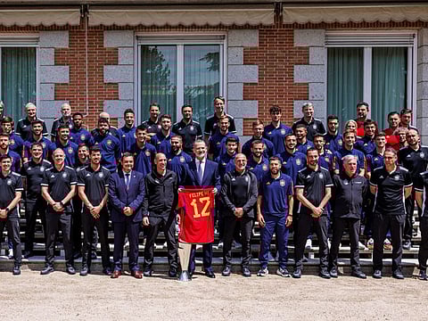 Spain's King Felipe VI holds a Spanish national football shirt as he poses with Spain's team during a reception a day after they won the Uefa Nations League final in Rotterdam, at Zarzuela Palace in Madrid on Monday.
