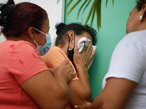 Relatives of inmates wait in distress outside the entrance to the women's prison in Tamara, on the outskirts of Tegucigalpa, Honduras, Tuesday, June 20, 2023.