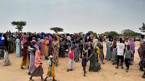Sudanese people, who fled the violence in their country, wait to be registered at the camp near the border between Sudan and Chad in Adre, Chad.
