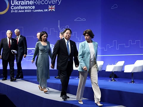 Japan's Foreign Minister Yoshimasa Hayashi and France's Foreign Minister Catherine Colonna walk on a stage on the first day of the Ukraine Recovery Conference in London, on June 21, 2023.