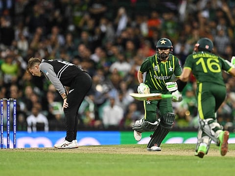 Lockie Ferguson of New Zealand reacts as Mohammad Rizwan and Babar Azam of Pakistan cross over during the T20 World Cup.
