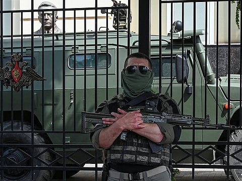 A fighter of Wagner private mercenary group stands guard in a street near the headquarters of the Southern Military District in the city of Rostov-on-Don, Russia, June 24, 2023.