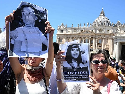 People hold placards with Emanuela Orlandi's portrait at the end of Pope's Angelus prayer in St. Peter's Square at the Vatican.