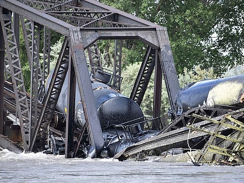 Several train cars are immersed in the Yellowstone River after a bridge collapse near Columbus, Mont., on Saturday, June 24, 2023.
