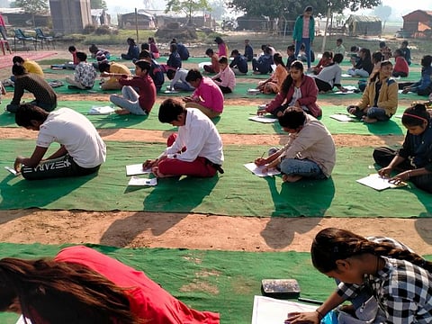 Students attend an open-air school project empowering around 300 slum children living in nearby clusters of slums in East Delhi, India.