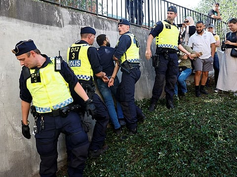 Police officers intervene after people respond to burning of the Quran (not pictured) outside Stockholm's central mosque in Stockholm on June 28, 2023.