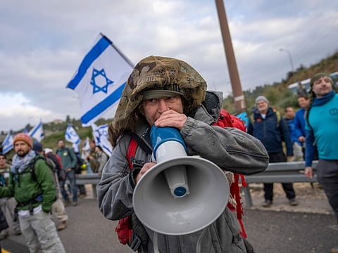 Israeli military reservists protest against the plans by Prime Minister Benjamin Netanyahu's government to overhaul the judicial system, on a freeway from Tel Aviv to Jerusalem, on Feb. 9, 2023.