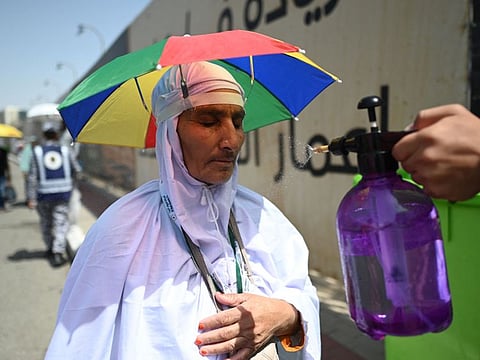 A member of the Saudi security forces sprays water on Muslim pilgrims during the Hajj pilgrimage in Mina, near Saudi Arabia's holy city of Mecca on June 29, 2023.
