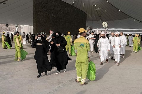 Cleaners line up in front of pilgrims after they cast stones at a pillar in the symbolic stoning of the devil, the last rite of the annual Hajj pilgrimage, in Mina near Mecca.