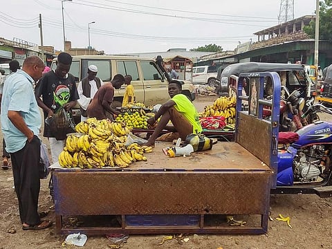 People buy fruits from a street vendor at a market in Gadaref city in war-torn Sudan on July 2, 2023.